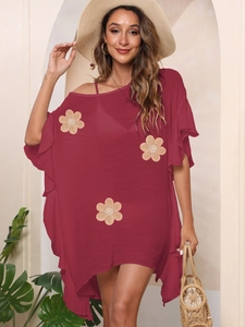 Close-up of beige woven flower appliques and fringe on wine red beach cover-up dress