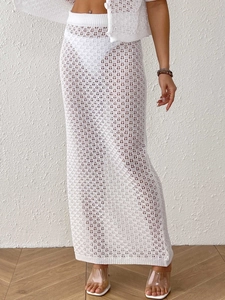 Close-up of white crochet knit two-piece set featuring textured hollow-out skirt and button top