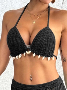 Close-up of handmade black crochet bikini top with bohemian shell fringe detailing