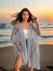 Detailed close-up of grey crochet lace cover-up with intricate geometric embroidery patterns