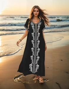 Close-up of white vine embroidery on the black bohemian kaftan beach dress sleeves