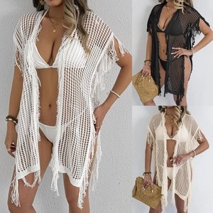 Detail van gehaakte strandoutfit met opengewerkt meshpatroon en decoratieve franjes
