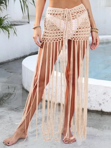 Dettaglio gonna da spiaggia all'uncinetto con motivi geometrici e lunghe nappe