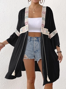 Dettaglio del cardigan boho con inserti in pizzo e ricami geometrici colorati