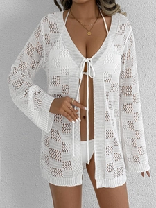 Détail de ce cardigan de plage au crochet blanc avec liens frontaux et motifs ajourés