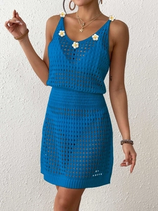 Dettaglio dell'abito in maglia blu con fiori 3D bianchi e texture a traforo raffinata