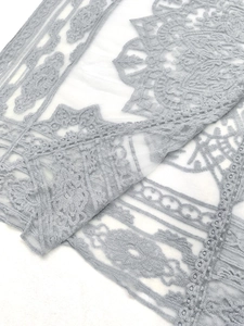 Detailed macro view of delicate floral lace embroidery and mesh fabric for sun protection