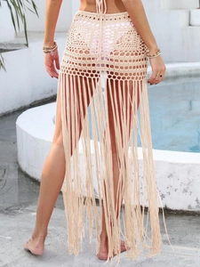 Dettaglio gonna mare all'uncinetto con lunghe nappe e trama in maglia traforata beige