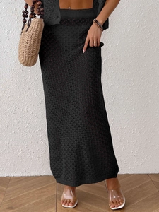 Close-up of black hollow-out crochet knit long skirt and matching cardigan set