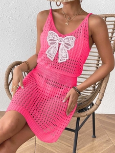 Detail der Strickstruktur des rosa Häkel-Strandkleids mit weißer Spitzen-Schmetterlings-Applikation
