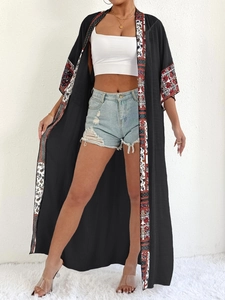 Detail view of long black sun-protection cardigan with geometric bohemian floral patterns