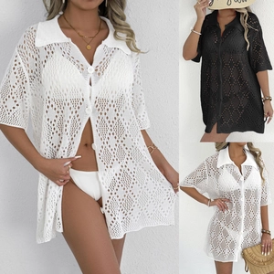 Detail of crochet knit texture and white buttons on a polo neck beach cover-up shirt