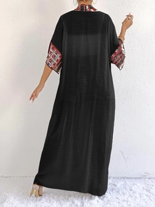 Back view of women's long black kaftan with ethnic geometric pattern on sleeves and neck