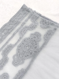 Macro shot of light blue water-soluble lace fabric with floral embroidery detail