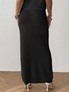 Back view of a black crochet maxi skirt featuring a hollow mesh texture and a boho style