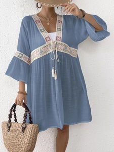 Dettagli di ricamo e paillettes su abito boho blu con nappe e pizzo raffinato