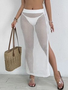 Detail of white crochet beach cover-up skirt featuring high slit and knit mesh pattern