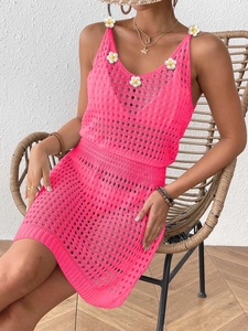 Dettaglio dell'abito all'uncinetto rosa con applicazioni di margherite e maglia traforata
