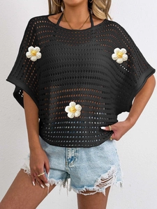 Detail of black crochet knit hollow top featuring 3D white flower patches and batwing sleeves