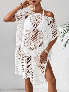 Détail d'une robe de plage blanche crochetée avec maille ajourée et fente latérale