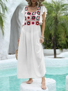 Detail of colorful crochet patchwork and white ruffle sleeves on a beach maxi dress