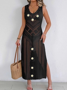 Détail de la robe de plage crochetée noire avec fleurs appliquées et fente latérale