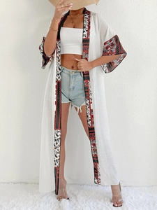 Detail of ethnic floral trim on white long kimono cardigan beach cover-up for women