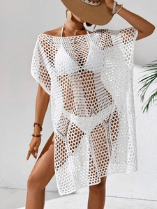 Détail de la robe de plage en crochet blanc montrant la texture ajourée et les mailles
