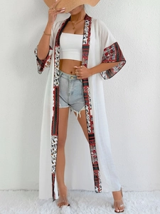 Detailed close-up of ethnic print cuffs on a white long sun protection kimono cardigan