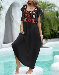 Detail of colorful hand-crocheted floral bodice on a black bohemian beach dress