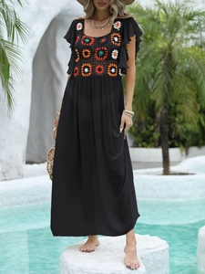 Bohemian black vacation maxi dress with colorful crochet floral details and ruffle sleeves
