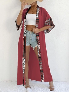 Close-up of bohemian cardigan with wine red fabric and floral print stitching detail