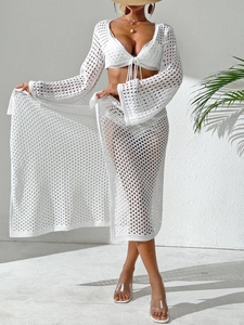 Detail of white crochet beach cover-up set showing intricate knit patterns and mesh texture