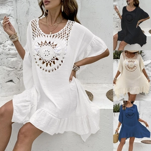 Detail view of crochet knit patterns and textured fabric on beach cover-up dress