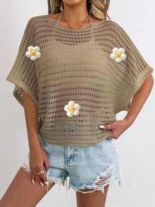 Close-up of khaki open-work knit top with handcrafted white crochet flower detailing