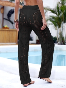 Detail of black crochet hollow-out beach pants with geometric knit pattern and high waist