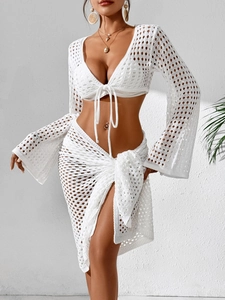 Detail of white crochet beach set showing hollow knit texture and side tie skirt