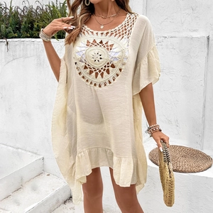 Macro detail of bohemian crochet mandala pattern on a beige beach cover-up dress