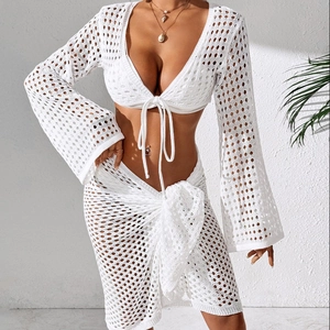 Close-up of white crochet beach set with intricate hollow out knit and tie-front details