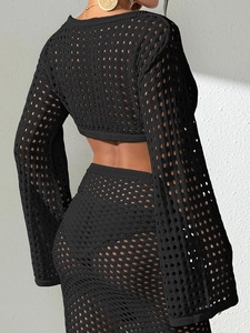 Gros plan sur la texture en maille crochetée noire et la finition détaillée du crop top