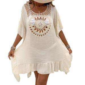 Detailed close-up of intricate hollow crochet patterns on bohemian ivory beach cover-up