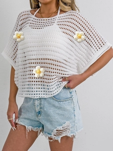 Detailed knit texture of white crochet hollow top with yellow 3D daisy floral appliques