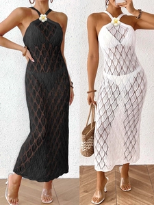Detail of crochet hollow out halter beach dress with floral accent in black and white