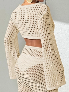 Détail de la texture crochetée crème et des manches évasées sur le haut de plage