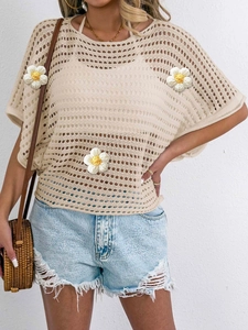 Detail of beige hollow crochet knit top featuring 3D floral appliqués and geometric patterns