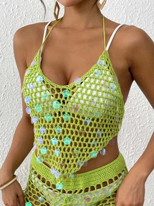 Détail du haut licou en crochet vert avec sequins et texture en maille ajourée