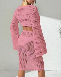 Detail view of pink crochet two-piece beach set featuring long sleeve crop top and midi skirt