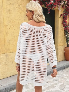 Detail of white waffle crochet texture on a long sleeve beach cover-up with open knit