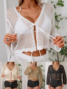 Dettaglio della trama all'uncinetto di un cardigan da donna con lacci e traforato