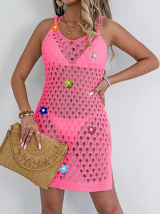Detail of vibrant neon pink crochet beach dress with colorful floral embroidery